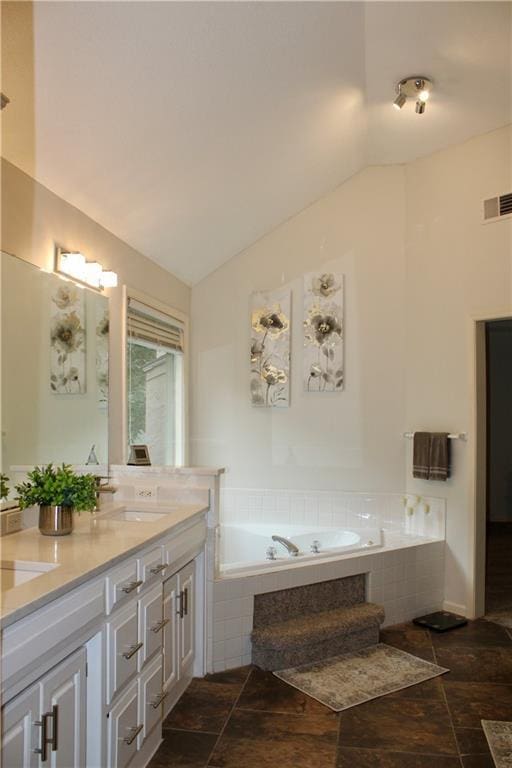 13810 W 53rd St, Shawnee, KS 66216 - bathroom featuring a garden tub, vaulted ceiling, double vanity, and stone finish floors