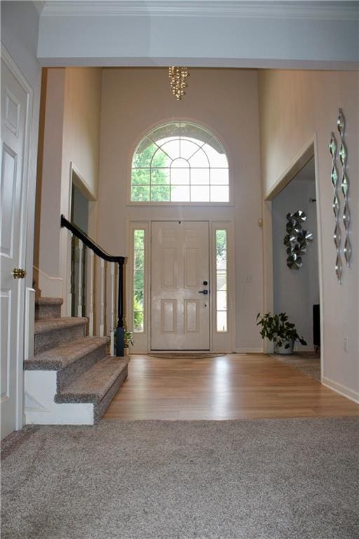 13810 W 53rd St, Shawnee, KS 66216 - foyer featuring stairway, wood finished floors, a towering ceiling, and ornamental molding