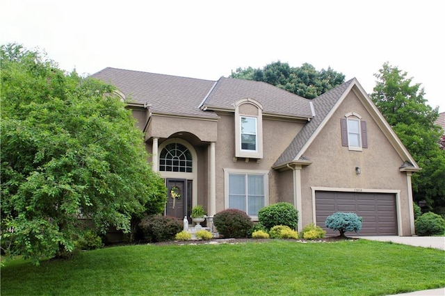 13810 W 53rd St, Shawnee, KS 66216 - view of front facade with driveway, stucco siding, a front lawn, a garage, and roof with shingles