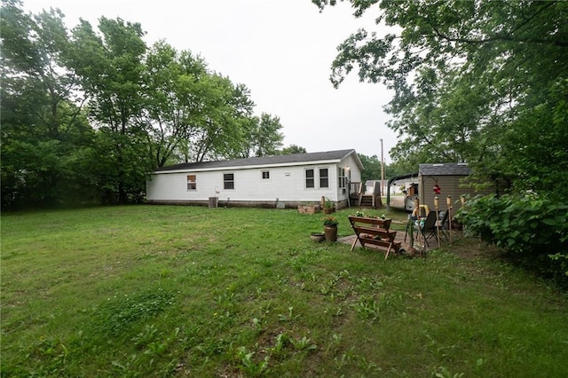 406 Cheyenne Ave, Coffeyville, KS 67337 - rear view of house with a lawn, a wooden deck, and an outbuilding