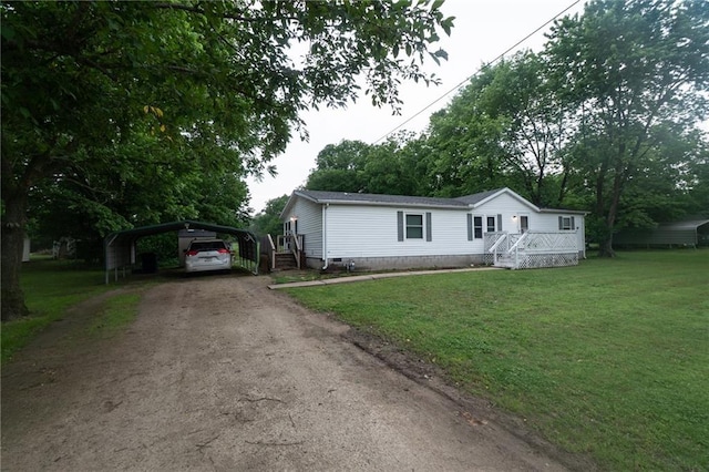 406 Cheyenne Ave, Coffeyville, KS 67337 - manufactured / mobile home with asphalt driveway, a detached carport, a front yard, and crawl space