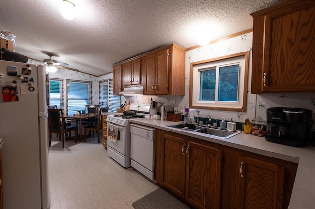 406 Cheyenne Ave, Coffeyville, KS 67337 - kitchen with white appliances, a sink, vaulted ceiling, under cabinet range hood, and ceiling fan