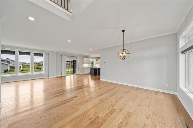 1709 SW Hightown Dr, Lees Summit, MO 64082 - unfurnished living room with a chandelier, ornamental molding, light wood-style floors, and recessed lighting