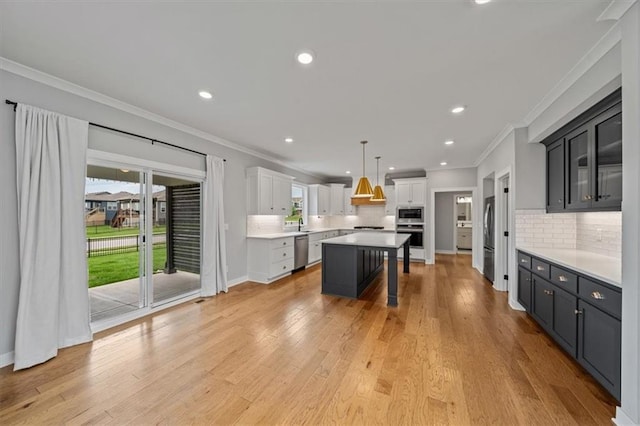 1709 SW Hightown Dr, Lees Summit, MO 64082 - kitchen with appliances with stainless steel finishes, tasteful backsplash, a kitchen island, a kitchen bar, and crown molding