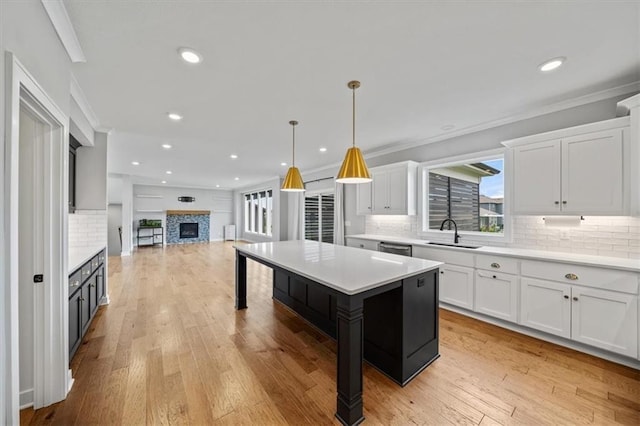 1709 SW Hightown Dr, Lees Summit, MO 64082 - kitchen with crown molding, white cabinetry, light countertops, decorative backsplash, and open floor plan