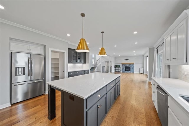1709 SW Hightown Dr, Lees Summit, MO 64082 - kitchen with stainless steel appliances, a kitchen island, tasteful backsplash, ornamental molding, and recessed lighting