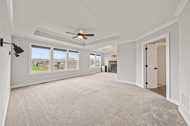 1709 SW Hightown Dr, Lees Summit, MO 64082 - unfurnished living room featuring a fireplace, carpet floors, a ceiling fan, a tray ceiling, and ornamental molding