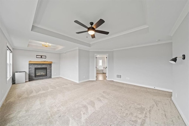 1709 SW Hightown Dr, Lees Summit, MO 64082 - unfurnished living room featuring a raised ceiling, a ceiling fan, healthy amount of natural light, carpet floors, and ornamental molding