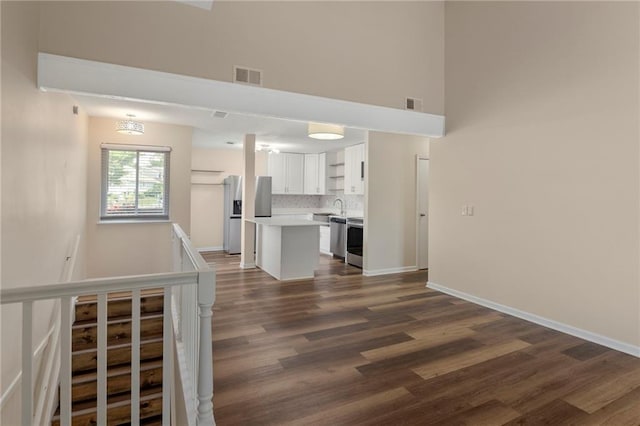 14107 W 88th St, Lenexa, KS 66215 - unfurnished living room with dark wood-style flooring and a towering ceiling