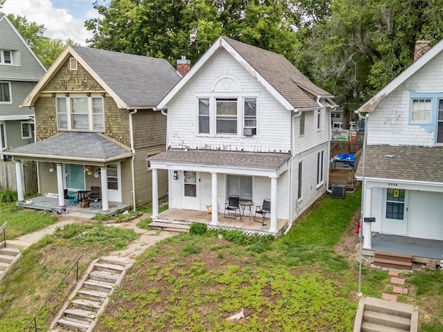 2517 Faraon St, Saint Joseph, MO 64501 - view of front facade with covered porch, a chimney, a shingled roof, and a front lawn