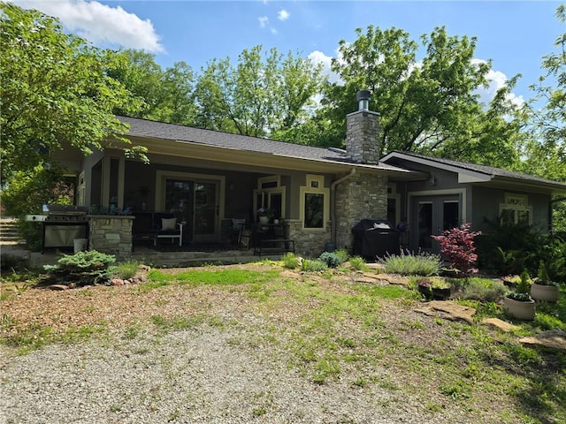 8050 SE Benner Lake Rd, Dearborn, MO 64439 - rear view of house featuring french doors, stone siding, a chimney, and a patio
