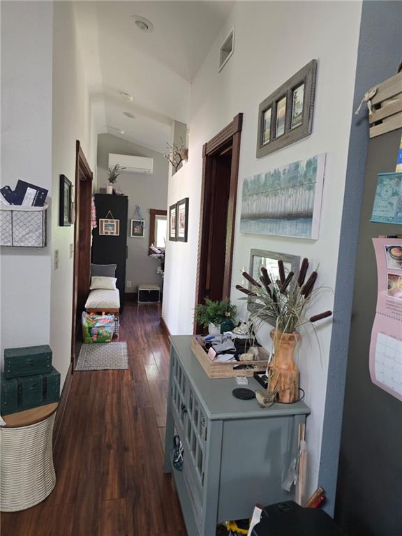 8050 SE Benner Lake Rd, Dearborn, MO 64439 - hallway with dark wood-style flooring, lofted ceiling, and a wall mounted AC