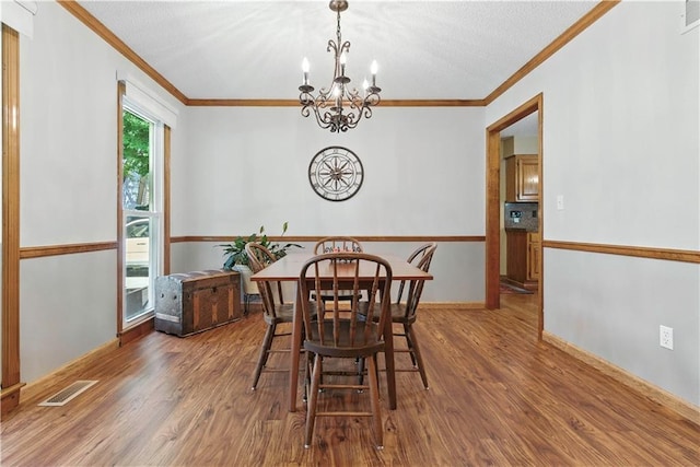 15206 W 85th St, Lenexa, KS 66219 - dining area with crown molding, a chandelier, and wood finished floors
