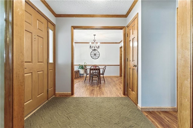 15206 W 85th St, Lenexa, KS 66219 - entryway featuring a chandelier, wood finished floors, crown molding, and a textured ceiling