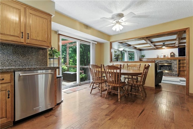 15206 W 85th St, Lenexa, KS 66219 - dining area with a ceiling fan, wood-type flooring, a fireplace, a textured ceiling, and beamed ceiling