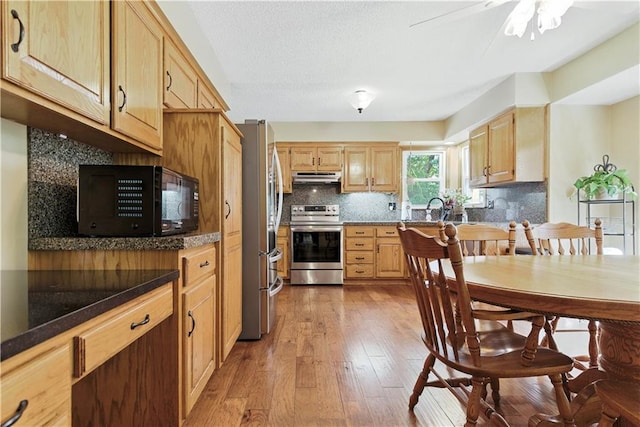 15206 W 85th St, Lenexa, KS 66219 - kitchen featuring stainless steel appliances, under cabinet range hood, light wood-type flooring, backsplash, and light brown cabinets