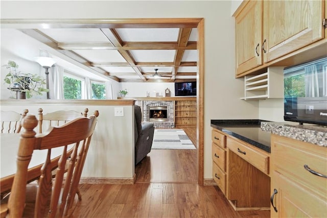 15206 W 85th St, Lenexa, KS 66219 - kitchen featuring light wood-style floors, a ceiling fan, a fireplace, light brown cabinetry, and beam ceiling