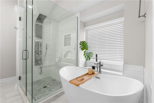 1021 NE Woodbury Ln, Lees Summit, MO 64086 - bathroom featuring a stall shower, a freestanding tub, and marble look tile flooring