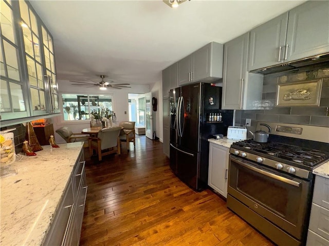11500 Orchard Rd, Kansas City, MO 64134 - kitchen featuring gas range, black fridge, decorative backsplash, and light stone counters