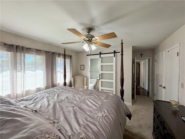 11500 Orchard Rd, Kansas City, MO 64134 - bedroom with a barn door, light colored carpet, ensuite bathroom, ceiling fan, and baseboards