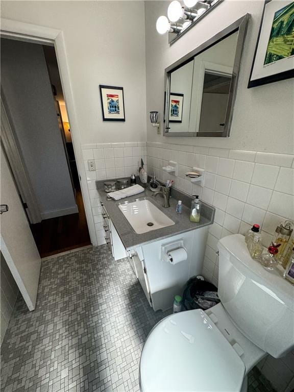 11500 Orchard Rd, Kansas City, MO 64134 - bathroom with tile walls, toilet, wainscoting, and vanity