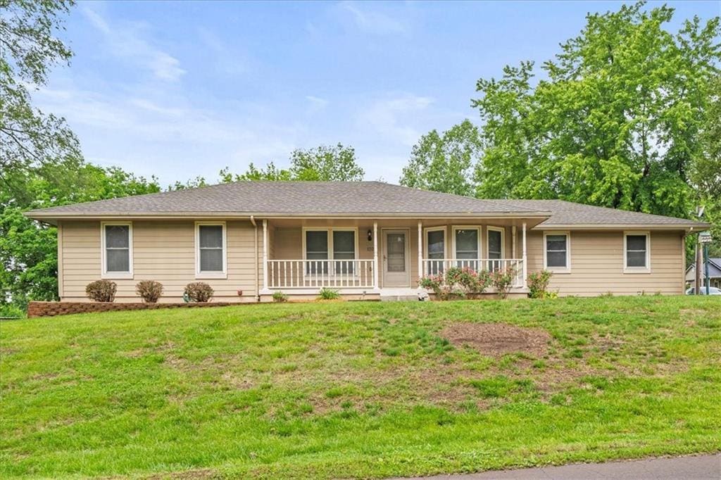 102 N Harrison St, Freeman, MO 64746 - ranch-style house with a porch and a front lawn