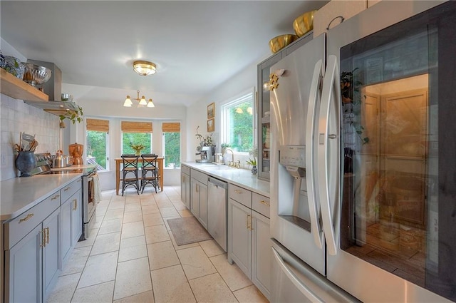 10236 Noland Rd, Lenexa, KS 66215 - kitchen with stainless steel appliances, open shelves, light countertops, tasteful backsplash, and gray cabinets