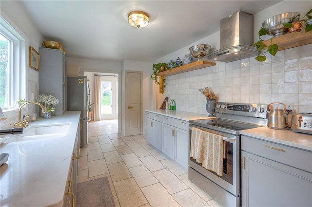 10236 Noland Rd, Lenexa, KS 66215 - kitchen featuring stainless steel appliances, island range hood, open shelves, decorative backsplash, and plenty of natural light