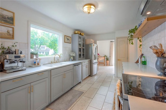 10236 Noland Rd, Lenexa, KS 66215 - kitchen with stainless steel appliances, a sink, gray cabinetry, and decorative backsplash