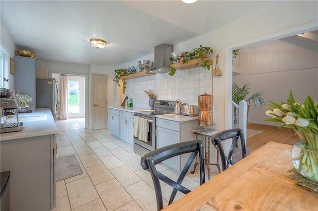 10236 Noland Rd, Lenexa, KS 66215 - kitchen with stainless steel appliances, island exhaust hood, open shelves, decorative backsplash, and light countertops