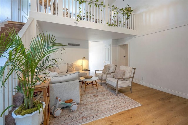 10236 Noland Rd, Lenexa, KS 66215 - living area with wood finished floors, a towering ceiling, baseboards, and healthy amount of natural light