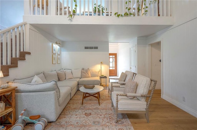 10236 Noland Rd, Lenexa, KS 66215 - living area with wood finished floors, a high ceiling, stairway, and baseboards