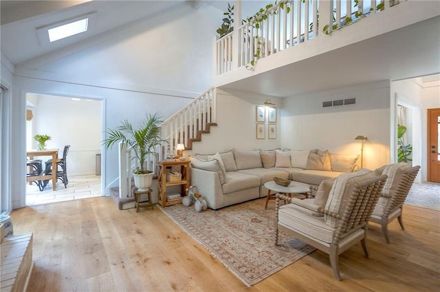 10236 Noland Rd, Lenexa, KS 66215 - living area featuring wood finished floors, high vaulted ceiling, and stairway