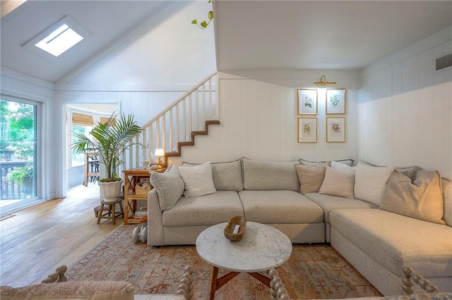 10236 Noland Rd, Lenexa, KS 66215 - living area featuring wood finished floors, stairs, a decorative wall, and lofted ceiling