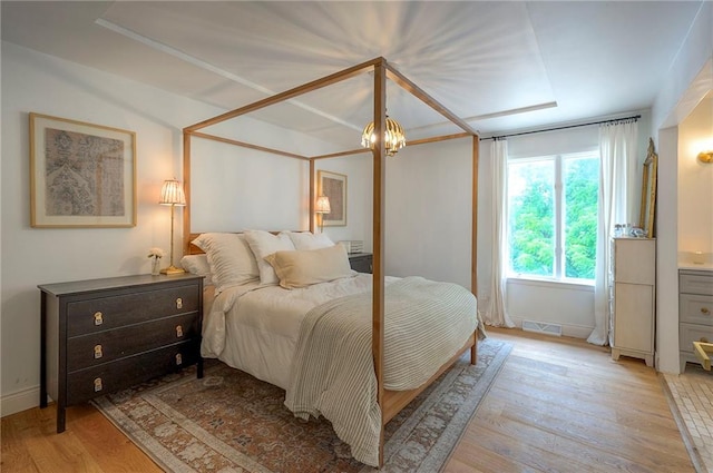 10236 Noland Rd, Lenexa, KS 66215 - bedroom featuring light wood-type flooring, baseboards, and a chandelier