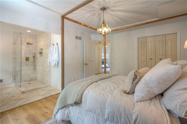 10236 Noland Rd, Lenexa, KS 66215 - bedroom featuring wood finished floors, a chandelier, a closet, and ensuite bath