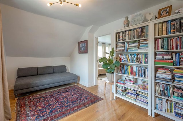 10236 Noland Rd, Lenexa, KS 66215 - sitting room with wood finished floors, lofted ceiling, baseboards, and a chandelier