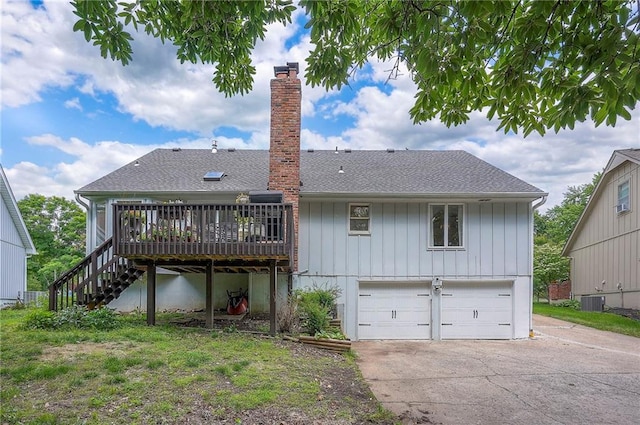 10236 Noland Rd, Lenexa, KS 66215 - back of house featuring a garage, concrete driveway, a deck, stairway, and a chimney