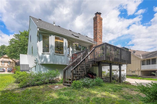 10236 Noland Rd, Lenexa, KS 66215 - back of property with stairway, a deck, a chimney, and roof with shingles