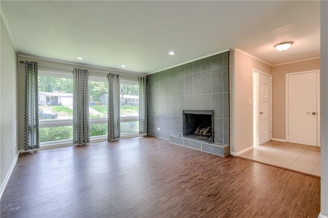 5112 Rock Creek Ln, Mission, KS 66205 - unfurnished living room featuring ornamental molding, wood finished floors, baseboards, a tiled fireplace, and recessed lighting