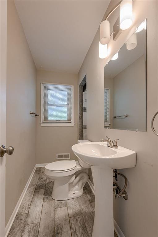 5112 Rock Creek Ln, Mission, KS 66205 - half bathroom featuring toilet, baseboards, and wood finished floors