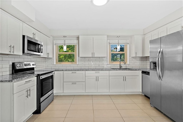 5112 Rock Creek Ln, Mission, KS 66205 - kitchen with stainless steel appliances, a sink, dark stone countertops, and white cabinetry