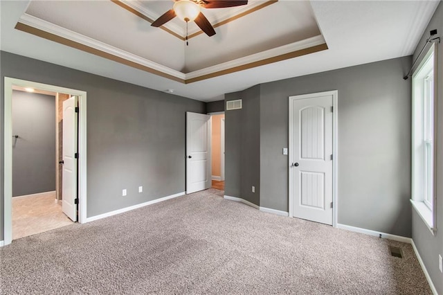 9 Platte Ridge Ct, Edgerton, MO 64444 - unfurnished bedroom with a tray ceiling, carpet flooring, multiple windows, and ornamental molding