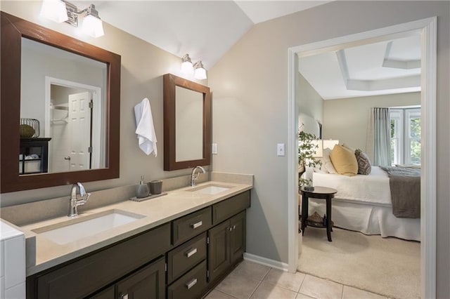 12577 S Alcan Cir, Olathe, KS 66062 - ensuite bathroom with double vanity, tile patterned floors, vaulted ceiling, and a raised ceiling
