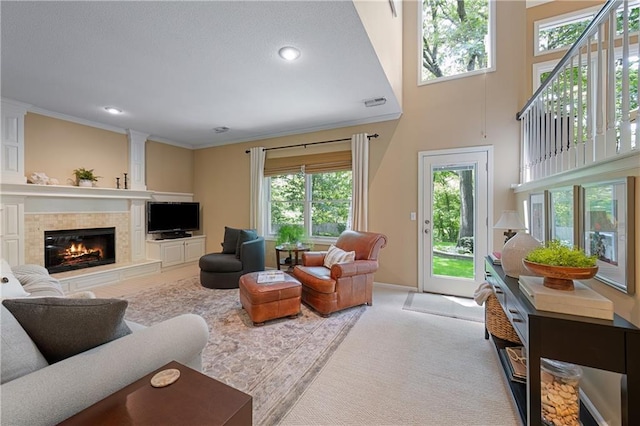 12577 S Alcan Cir, Olathe, KS 66062 - carpeted living area featuring a premium fireplace, ornamental molding, recessed lighting, and a towering ceiling