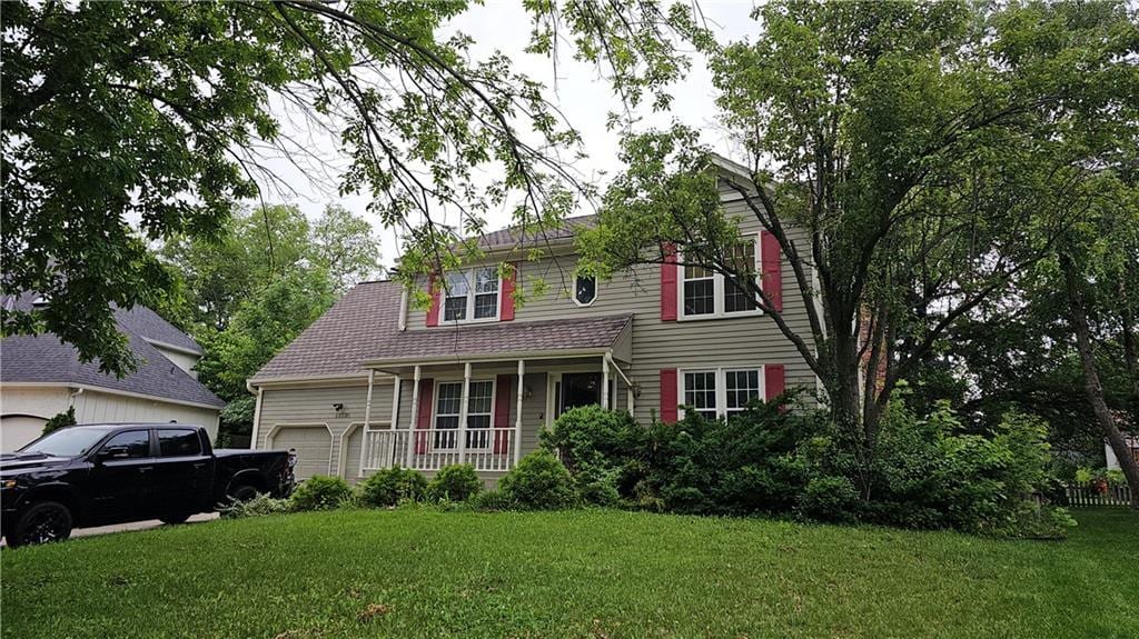 15320 W 92nd Pl, Lenexa, KS 66219 - view of front facade with an attached garage, covered porch, and a front lawn