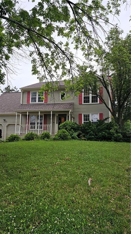 15320 W 92nd Pl, Lenexa, KS 66219 - traditional-style home with a porch, a garage, and a front lawn