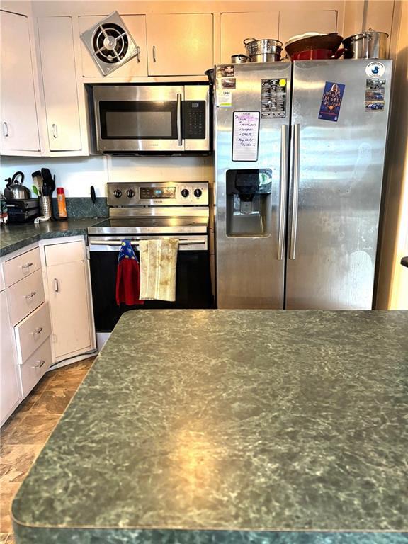 1024 Iowa St, Lawrence, KS 66044 - kitchen with appliances with stainless steel finishes and white cabinets