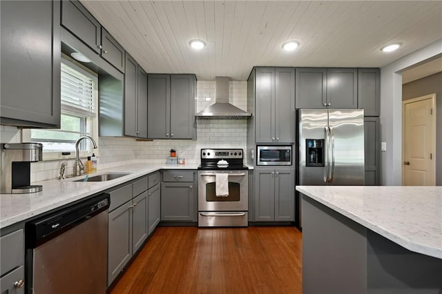 701 N Apache Dr, Independence, MO 64056 - kitchen with wall chimney exhaust hood, stainless steel appliances, a sink, gray cabinets, and light stone countertops