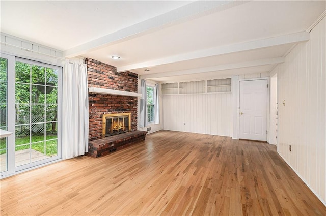 9601 W 97th St, Overland Park, KS 66212 - unfurnished living room with beam ceiling, wood finished floors, a brick fireplace, and wooden walls